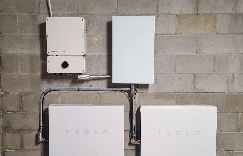 Two Tesla Powerwall 2 batteries installed in a residential basement.