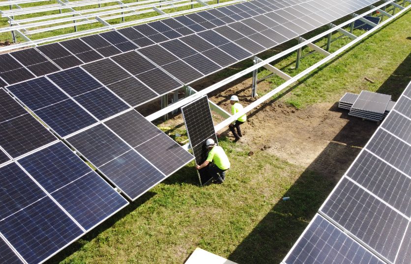 Solar installers setting modules on solar racking.