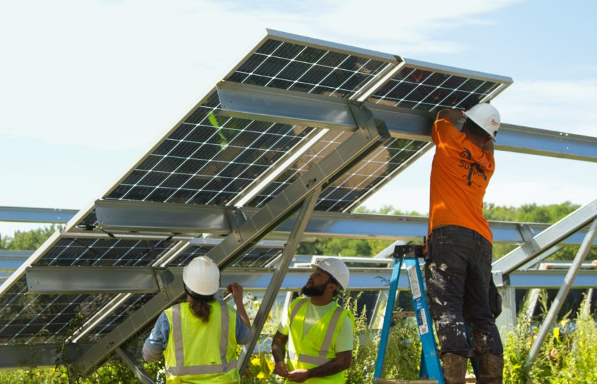 Solar installers securing solar modules and racking.