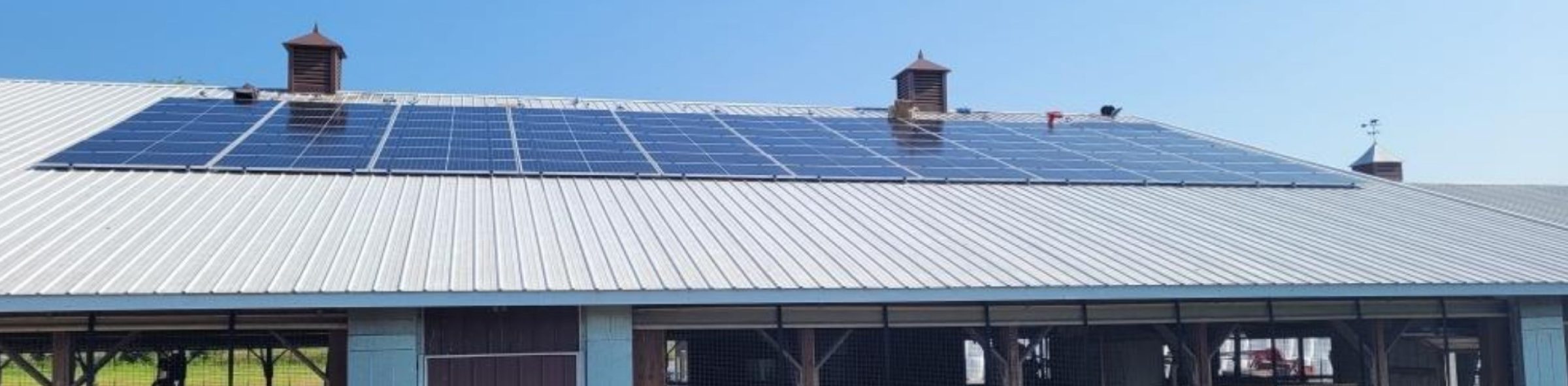 Solar panels installed on a cattle ranch roof.