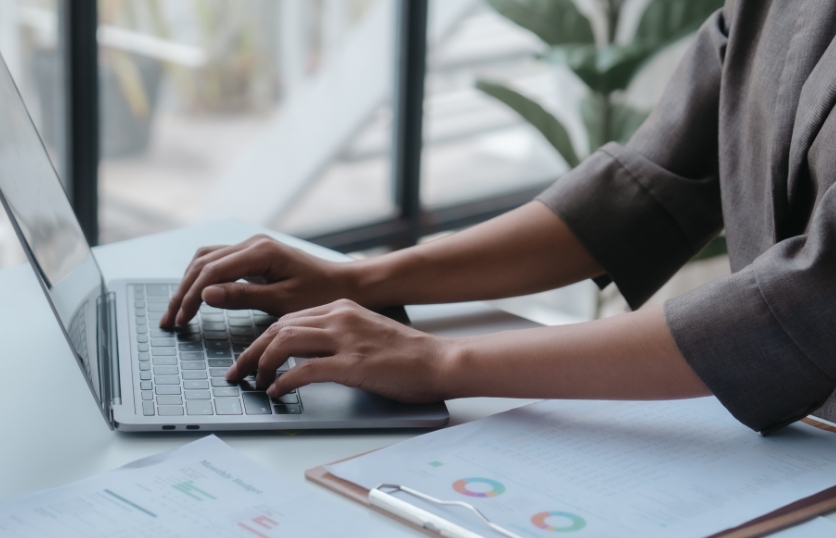 Individual typing on a laptop