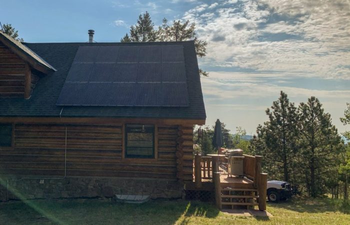 A large modern home with solar panels across four different roof planes.